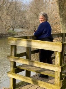 Inspired action taker Tina Zion on deck overlooking river